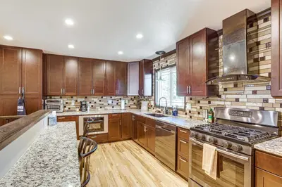 a kitchen with wooden cabinets and stainless steel appliances at Pet-Friendly Retreat with Fenced Yard in Aurora in Aurora