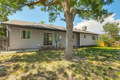 a house with a tree in the yard at Pet-Friendly Retreat with Fenced Yard in Aurora in Aurora