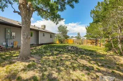 a yard with a tree and a house at Pet-Friendly Retreat with Fenced Yard in Aurora in Aurora