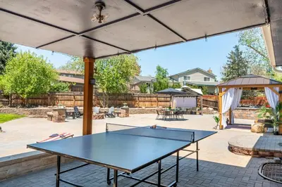 a ping pong table in the middle of a patio at Spacious 5BR, Epic Backyard, Perfect Gatherings in Arvada