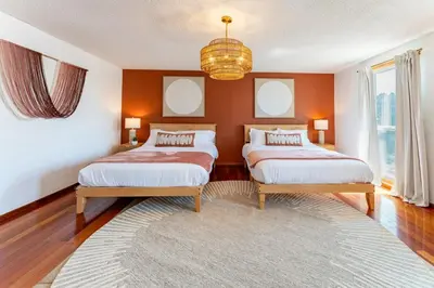 a bedroom with two beds and a chandelier at Spacious 5BR, Epic Backyard, Perfect Gatherings in Arvada