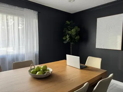 a dining room table with a bowl of fruit and a laptop at Spacious 5BR, Epic Backyard, Perfect Gatherings in Arvada