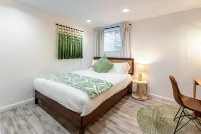 a bedroom with a bed with a green blanket on it at Spacious 5BR, Epic Backyard, Perfect Gatherings in Arvada