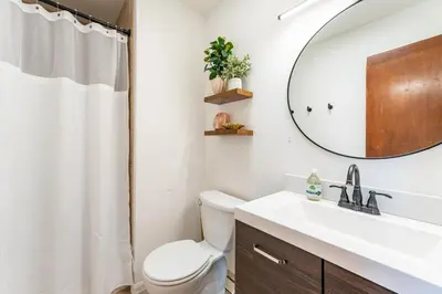 a bathroom with a toilet and a sink and a mirror at Spacious 5BR, Epic Backyard, Perfect Gatherings in Arvada