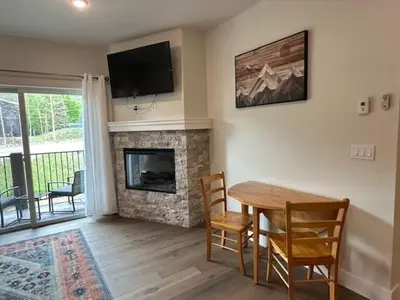 a living room with a table and a fireplace at Luxury Stay Meets Family Fun- Premier 1BR Retreat condo in Keystone