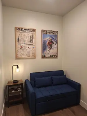 a living room with a blue couch and two posters at Luxury Stay Meets Family Fun- Premier 1BR Retreat condo in Keystone