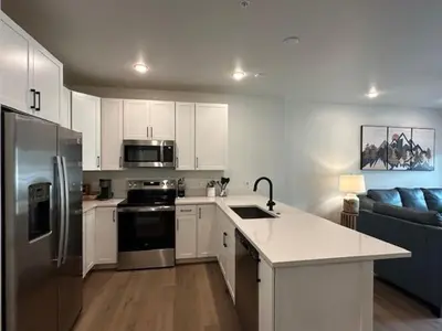 a kitchen with white cabinets and stainless steel appliances at Luxury Stay Meets Family Fun- Premier 1BR Retreat condo in Keystone