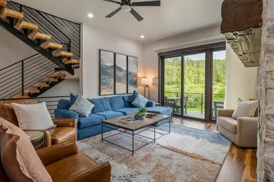 a living room with a blue couch and a table at Blue Horizon Chalet home in Winter Park