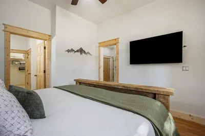 a bedroom with a bed and a flat screen tv at Estes Park Luxury Family Retreat in Estes Park