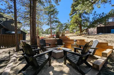 a patio with a table and chairs and trees at Estes Park Luxury Family Retreat in Estes Park