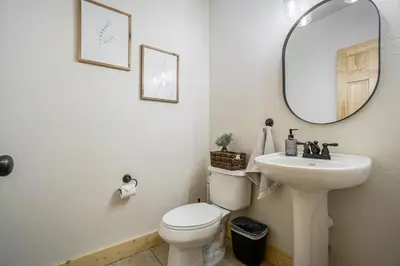 a bathroom with a sink and a toilet and a mirror at Estes Park Luxury Family Retreat in Estes Park