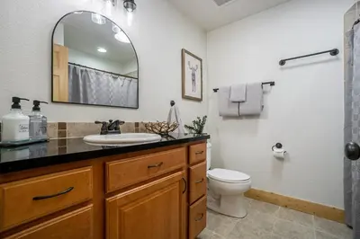 a bathroom with a sink and a toilet and a mirror at Estes Park Luxury Family Retreat in Estes Park