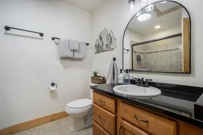 a bathroom with a sink and a toilet and a mirror at Estes Park Luxury Family Retreat in Estes Park