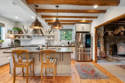 a kitchen with a large island with two bar stools at The River House home in Grand Lake