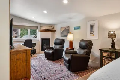 a living room with two chairs and a television at The River House home in Grand Lake