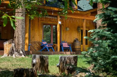 a cabin with two chairs on the front porch at The River House home in Grand Lake