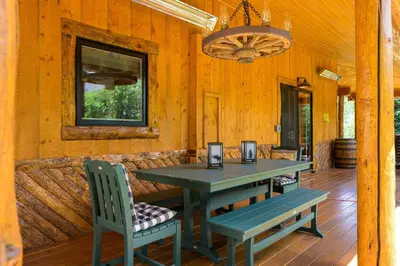 a wooden porch with a table and two chairs at The River House home in Grand Lake