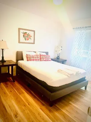 a bed in a bedroom with a wooden floor at Yedengel in DEN