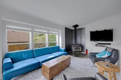 a living room with a blue couch and a tv at Large House On Horsetooth Reservoir - Great Views! in Fort Collins