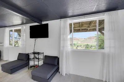a room with two chairs and a tv and a window at Large House On Horsetooth Reservoir - Great Views! in Fort Collins