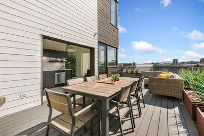 a patio with a wooden table and chairs on a deck at The Overlook - Luxe Old Town Condo with King Suite in Fort Collins