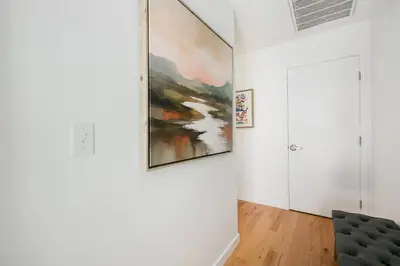 a living room with a large painting on the wall at The Overlook - Luxe Old Town Condo with King Suite in Fort Collins