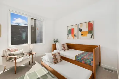 a bedroom with two beds and a chair and a window at The Overlook - Luxe Old Town Condo with King Suite in Fort Collins