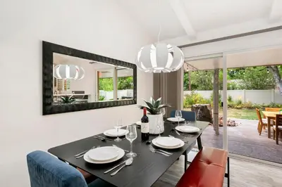 a dining room with a black table and a mirror at The Foundry Escape - Hot Tub, Bikes & Game Room in Loveland