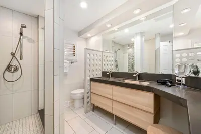 a bathroom with a sink and a toilet and a mirror at The Foundry Escape - Hot Tub, Bikes & Game Room in Loveland