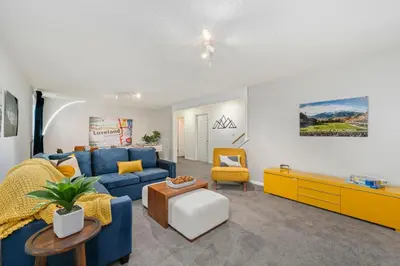 a living room with a blue couch and yellow furniture at The Foundry Escape - Hot Tub, Bikes & Game Room in Loveland