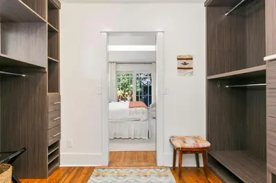 a bedroom with white walls and a door leading to a bed at Maple Courtyard - Old Town with King Suite & Piano in Fort Collins