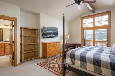 a bedroom with a bed and a dresser and a window at Cloudline Chalet townhouse in Winter Park