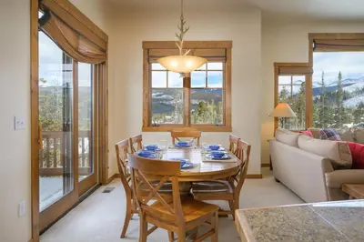 a dining room with a table and chairs and a couch at Cloudline Chalet townhouse in Winter Park