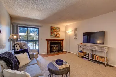 a living room with a couch and a tv and a fireplace at Mountainside Retreat - Sleeps 4 in Frisco
