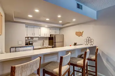 a kitchen with a bar with three chairs at it at Mountainside Retreat - Sleeps 4 in Frisco