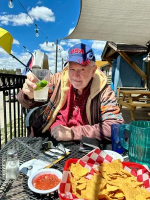 a woman sitting at a table with a drink and chips at Our Mountain Blessings Condominium Town Home - peaceful, cozy, and family friendly mountain getaway! The most ideally located unit in Meadow Ridge Resort, in Fraser