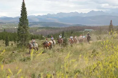 a group of people riding horses in a field at Our Mountain Blessings Condominium Town Home - peaceful, cozy, and family friendly mountain getaway! The most ideally located unit in Meadow Ridge Resort, in Fraser