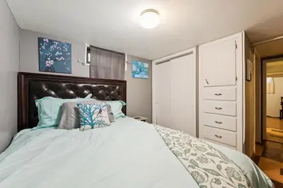 a bedroom with a large bed with a wooden headboard at Charming Home Near UNC & DT Greeley home in Greeley