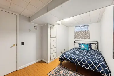 a bedroom with a bed with a blue comforter at Charming Home Near UNC & DT Greeley home in Greeley