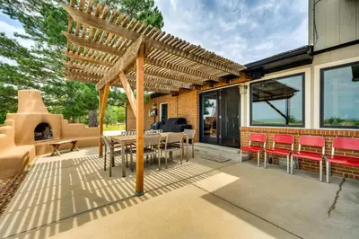 a patio with a wooden pergola and a table and chairs at Mtn-View Home with Pickleball Court in Louisville! in Louisville