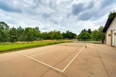 a tennis court in front of a building at Mtn-View Home with Pickleball Court in Louisville! in Louisville