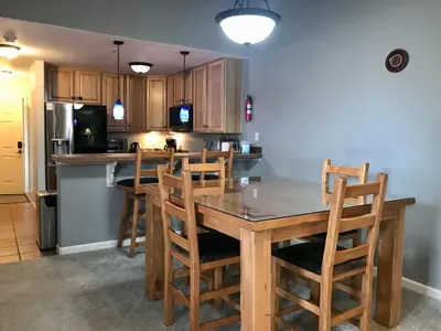 a kitchen with a wooden table and wooden chairs at Summit Vista Villa- Hike, Ski, Bike! in Fraser