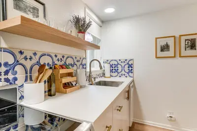 a kitchen with a sink and blue and white tiles at Walkable Apt with Off-Street Parking in Cheesman! in Denver