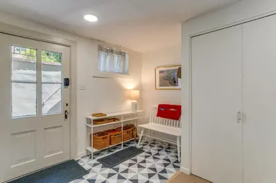 a hallway with a white door and a checkerboard floor at Walkable Apt with Off-Street Parking in Cheesman! in Denver