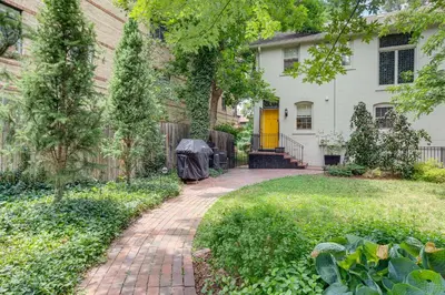 a brick walkway leading to a house with a yellow door at Walkable Apt with Off-Street Parking in Cheesman! in Denver