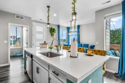 a kitchen with a sink and a large window at 10 min to DT, Luxe 4BR w Movie Theater, Game Room in Commerce City