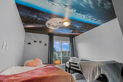 a bedroom with a ceiling with a view of the universe at 10 min to DT, Luxe 4BR w Movie Theater, Game Room in Commerce City