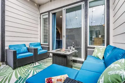 a patio with blue furniture and a table at 10 min to DT, Luxe 4BR w Movie Theater, Game Room in Commerce City