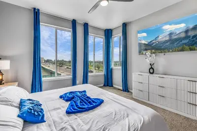 a bedroom with blue curtains and a bed with blue shoes on it at 10 min to DT, Luxe 4BR w Movie Theater, Game Room in Commerce City