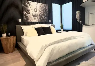 a bedroom with a large bed with white sheets and pillows at Luxury modern, Central Ski, No stairs, EV! in Silverthorne
